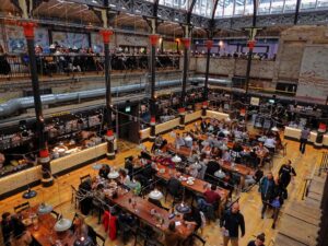 An aerial shot of the inside of Mackie Mayor, a food market serving ramen, pizza, fried chicken and more in a Grade 2 listed building in Manchester's Northern Quarter. 